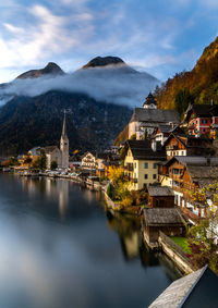 River amidst buildings in city against sky