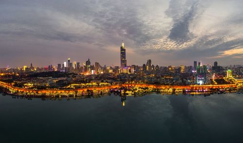 Illuminated buildings in city against sky