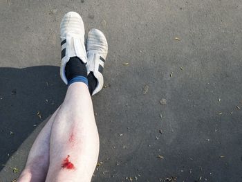 Low section of man standing on road