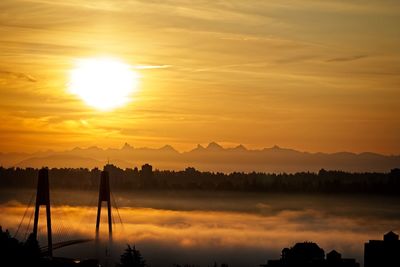 Scenic view of silhouette mountains against orange sky