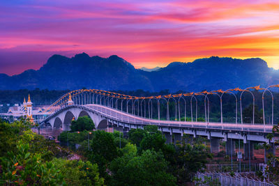 Bridge over river against sky during sunset