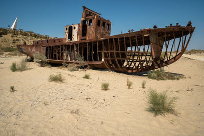 Abandoned truck on beach against clear sky