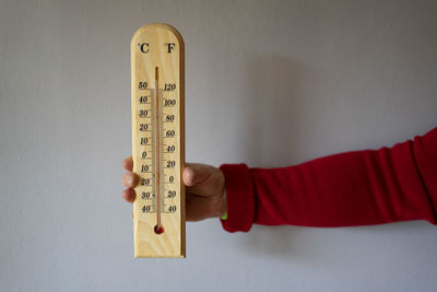 Woman dressed in red catching a wooden thermometer.