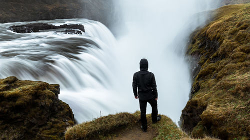 Rear view of man standing on cliff