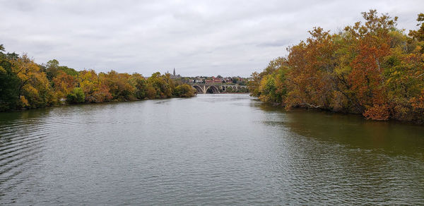 River amidst trees against sky during autumn