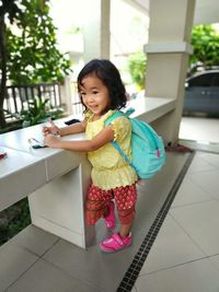 Portrait of smiling girl holding while standing on floor