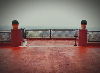 Red metal fence against sky