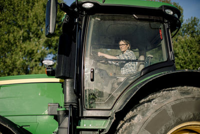 Female farmer driving tractor on sunny day