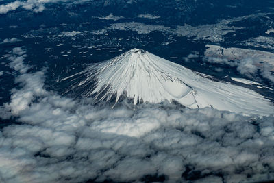 Aerial view of snow covered land against sky