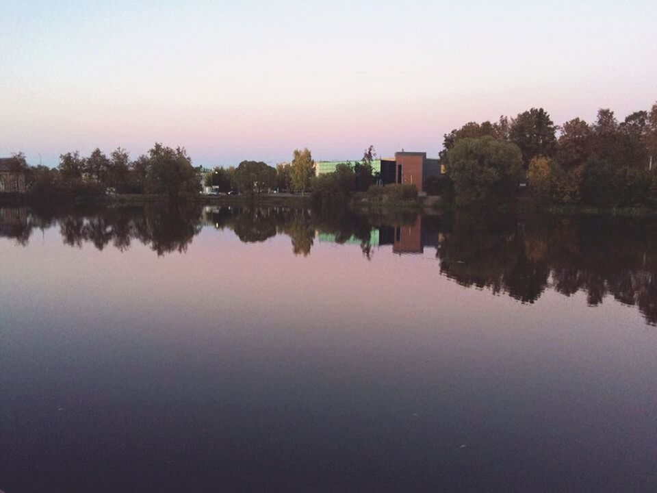 REFLECTION OF TREES AND SKY ON LAKE