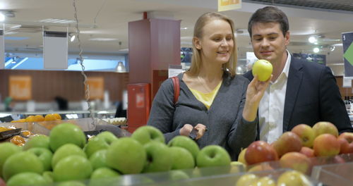 Young woman with fruits in store