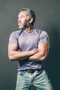 Man looking away while standing against black background