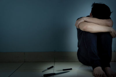 Man sitting on wall at home