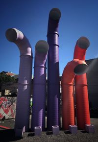 Low angle view of industry against clear blue sky