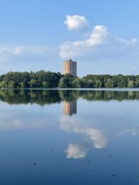 Reflection of building in lake against sky