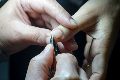 Close-up of beautician cleaning customer nails