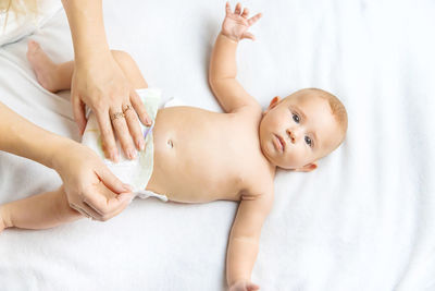 High angle view of baby lying on bed