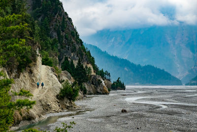 Scenic view of sea by mountains against sky