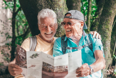 Portrait of smiling friends using digital tablet