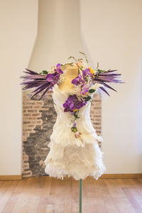 Flower vase on table against wall at home