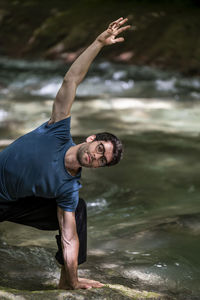 Full length of young woman exercising in lake