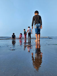 People on beach against sky