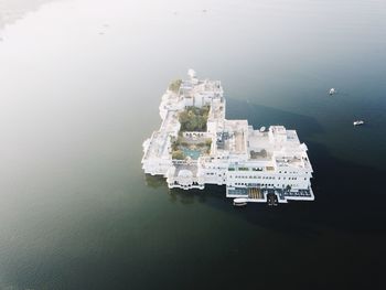 High angle view of city by sea against sky