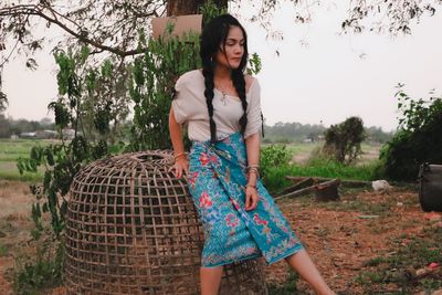 Young woman standing against trees