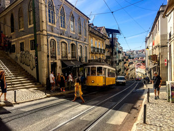 People walking on street amidst buildings in city