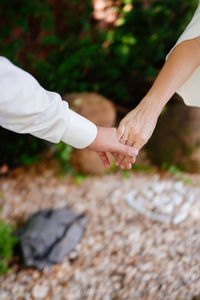 Cropped image of couple holding hands outdoors