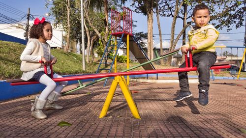 Boy sitting on swing at playground