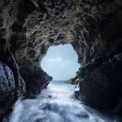 Scenic view of sea seen through cave