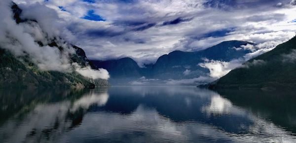 Scenic view of lake by mountains against sky