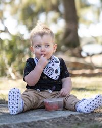 Portrait of cute boy sitting outdoors