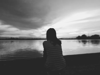 Woman looking at lake against sky