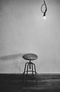Low angle view of lamp on table against wall
