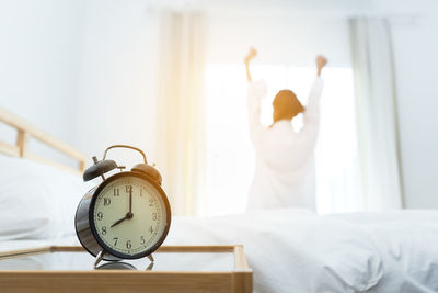 Close-up of clock on bed at home