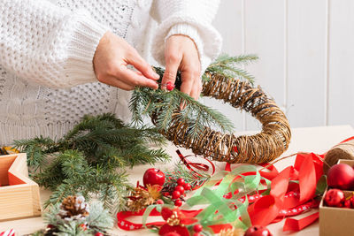 Midsection of woman with christmas decorations on table