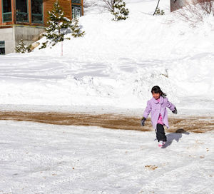 Full length of woman standing on snow covered land