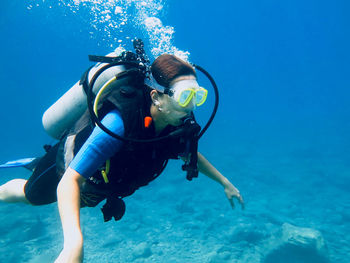 Brunette girl scuba diving in the warm ocean waters of southern turkey