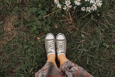 Low section of woman standing on field