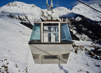 Cabin of cable car against snow covered mountain