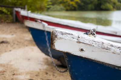 Close-up of boat moored at lake