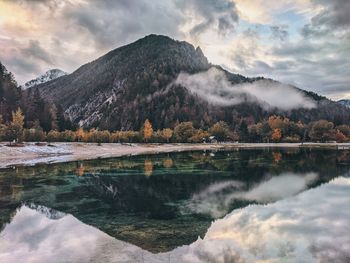 Scenic view of lake by mountains against sky