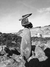 Stack of rocks on land against sky