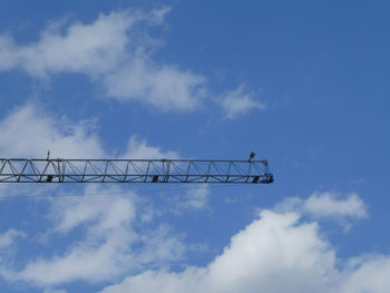 Low angle view of crane against blue sky