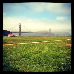 Bridge over landscape against cloudy sky