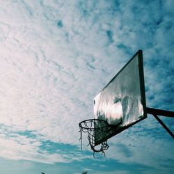 Low angle view of basketball hoop against cloudy sky