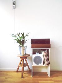 Music system by potted plant against wall at home