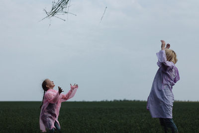 Full length of girl standing on field against clear sky